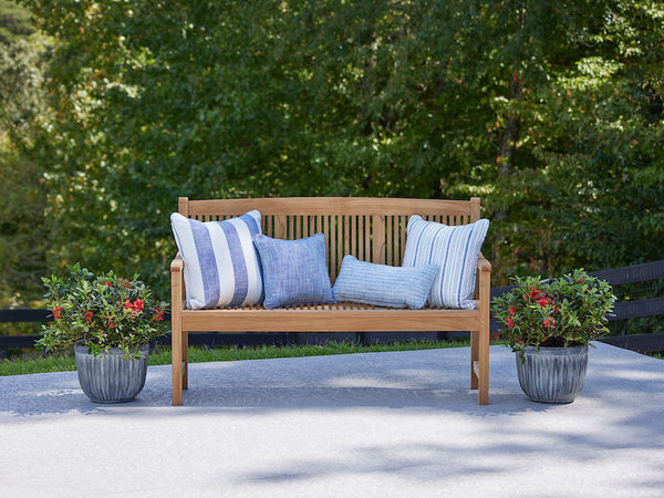 Image of teak bench with blue pillows